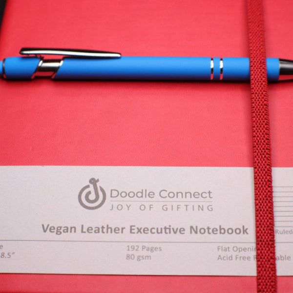 Red vegan leather executive notebook with a blue pen on a red background, featuring the Doodle Connect brand.