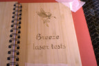 Wooden board with 'Breeze laser tests' engraving on a wooden surface